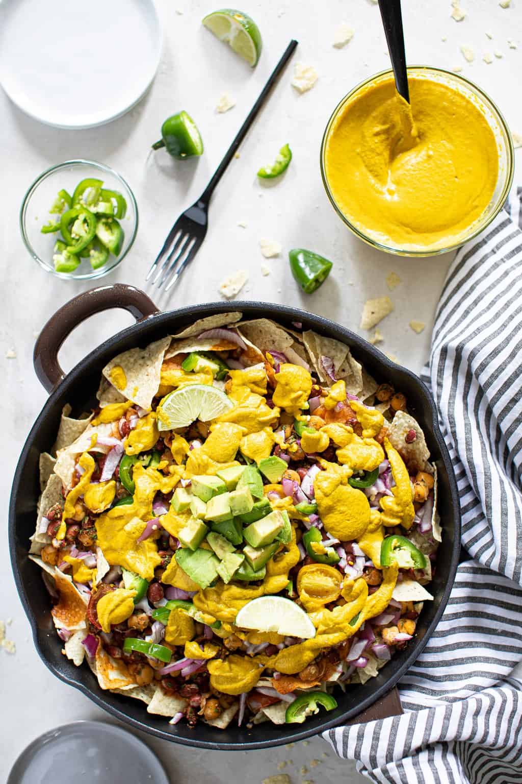 Loaded Vegan Queso Skillet Nachos with chickpeas, red kidney beans and cashew-based queso