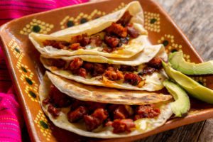 Traditional mexican quesadillas with vegan chorizo on wooden background